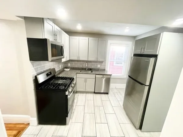 a kitchen with a sink a refrigerator a stove a microwave and cabinets