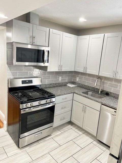 1 Ropes Street, Unit 2 Salem, MA 01970 - Photo 2 of 16 a kitchen with granite countertop white cabinets and appliances