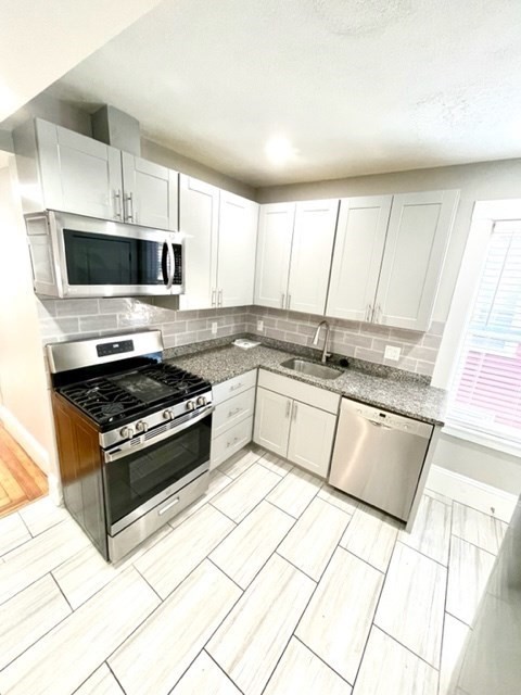1 Ropes Street, Unit 2 Salem, MA 01970 - Photo 3 of 16 a kitchen with stainless steel appliances granite countertop a stove a sink and a microwave