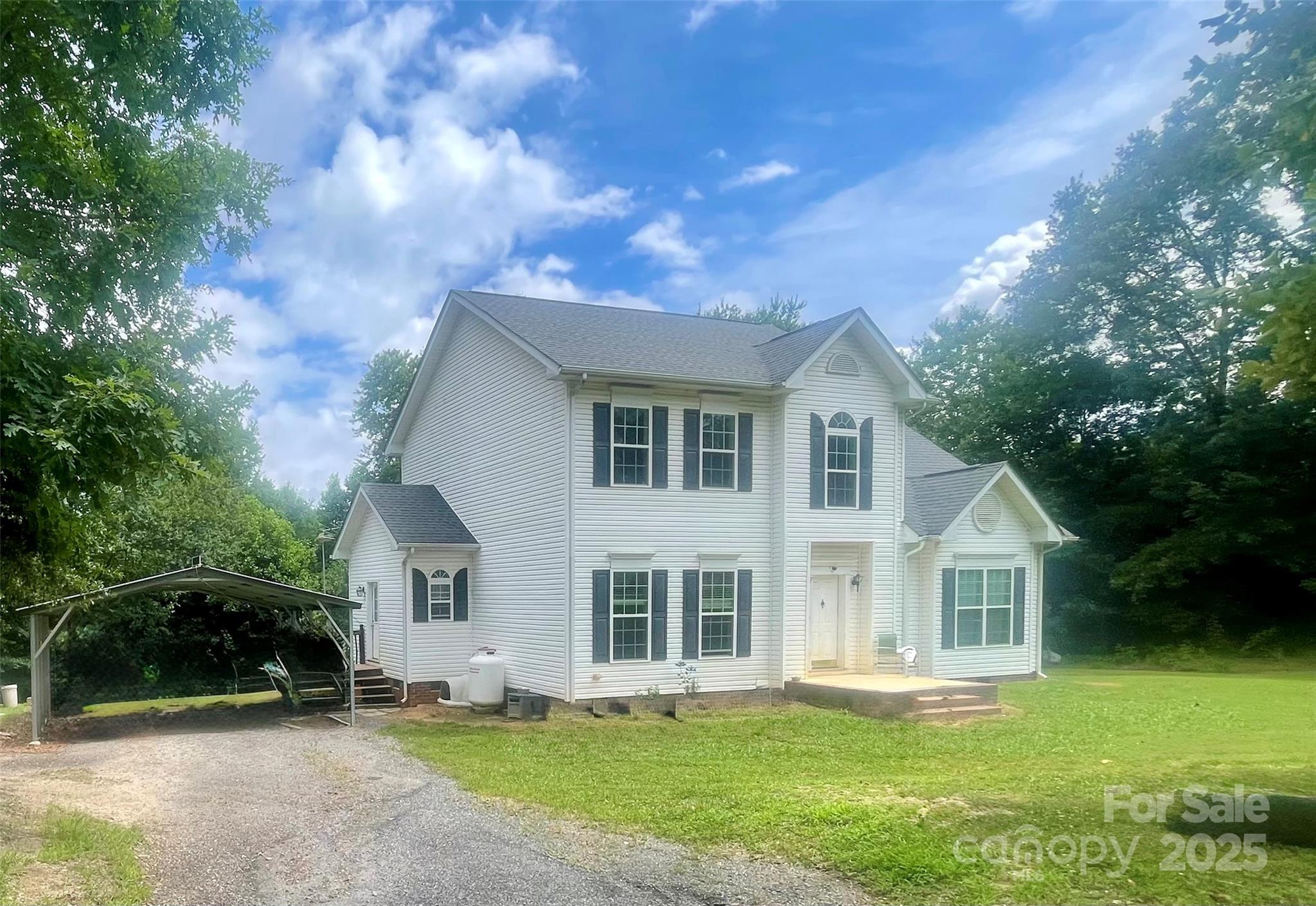 a front view of a house with a garden and trees