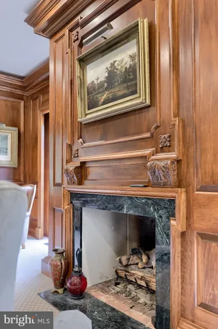a hallway with white cabinets and chandelier