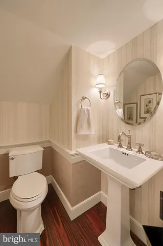 a bed sitting in a spacious bedroom next to a window and a chandelier