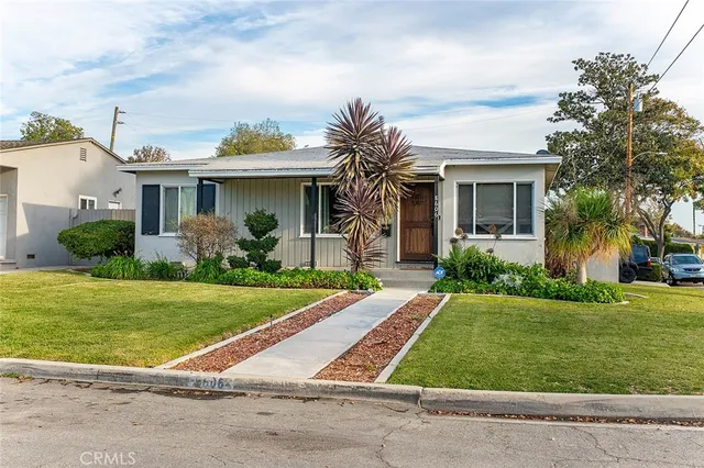 a front view of a house with a garden and plants