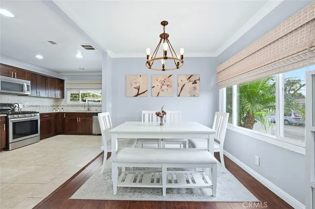a living room with stainless steel appliances furniture a rug and a large window