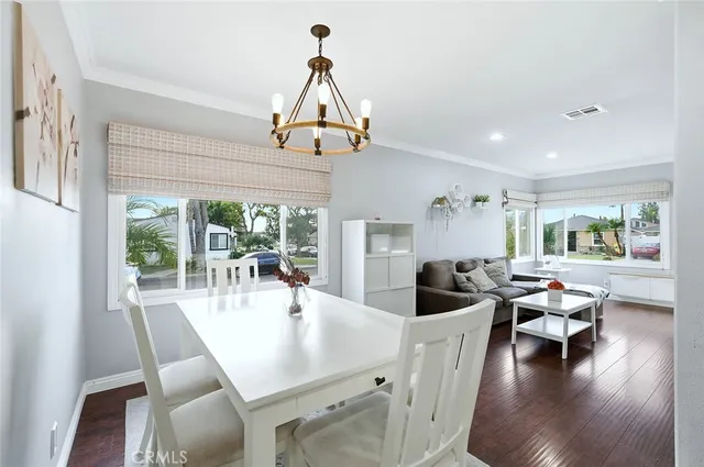 a view of a dining room with furniture wooden floor and chandelier