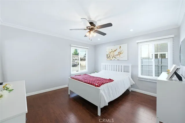 a bedroom with a bed and a large window with wooden floor