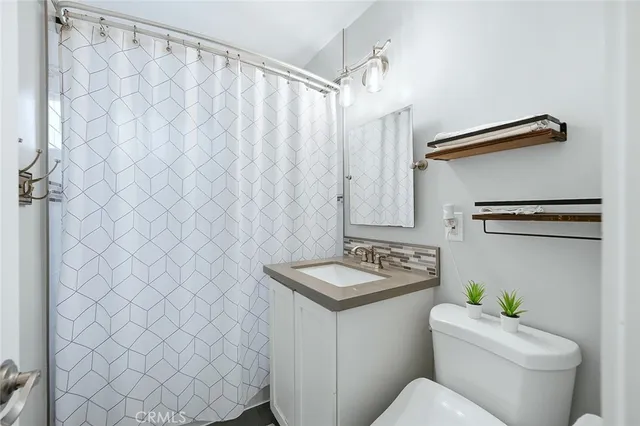 a bathroom with a sink toilet and a mirror