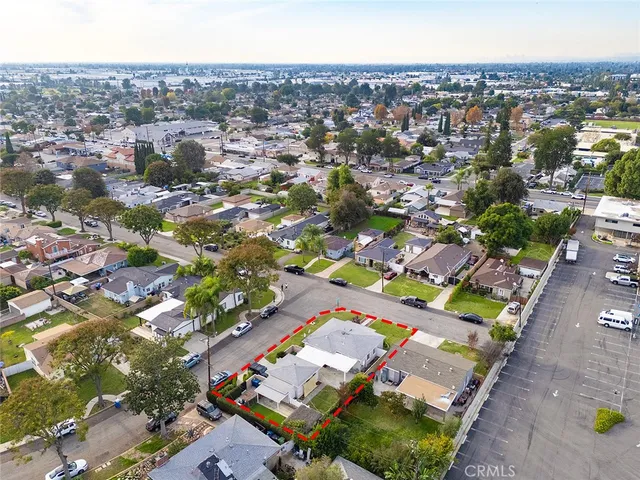 an aerial view of residential houses with outdoor space and parking