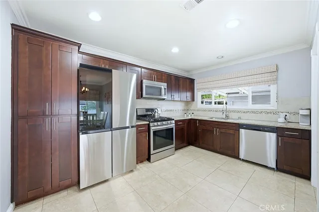 a large kitchen with stainless steel appliances granite countertop a stove and a sink