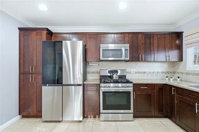 a kitchen with stainless steel appliances granite countertop a refrigerator stove a sink and dishwasher