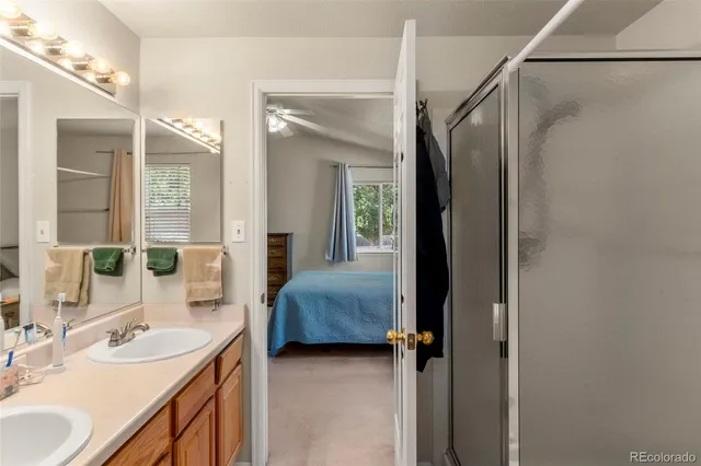 a en suite bathroom with a double vanity sink a mirror and a shower