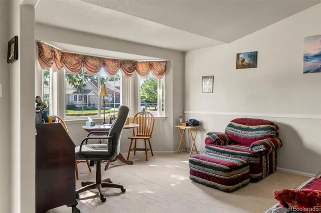 a living room with furniture a piano and a floor to ceiling window
