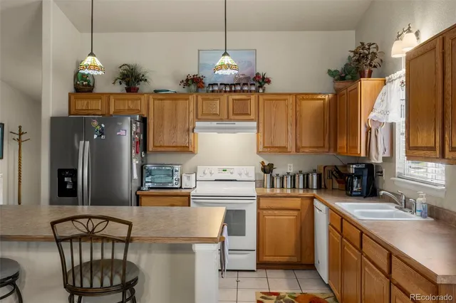a kitchen with stainless steel appliances granite countertop a sink a stove and a refrigerator