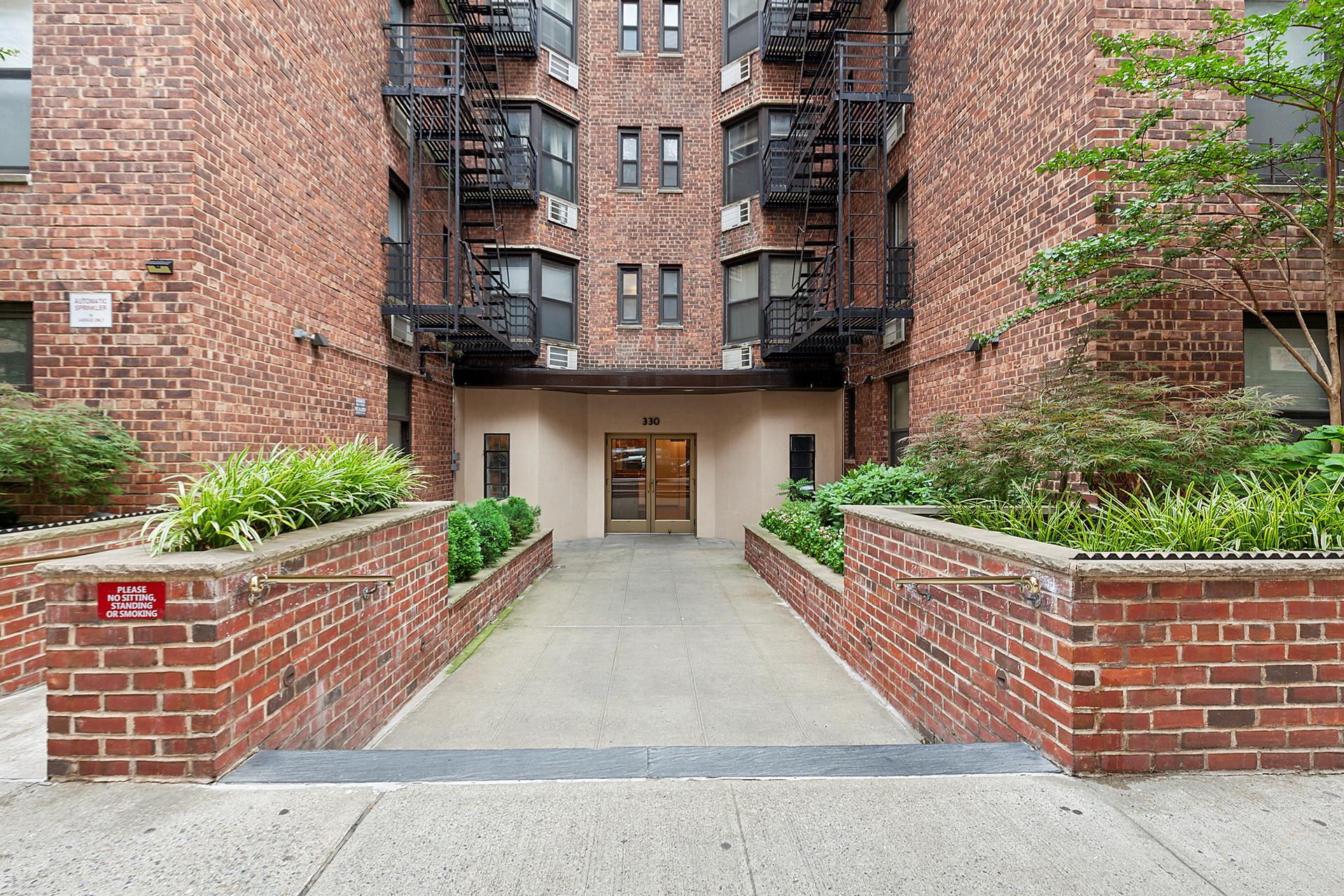 330 East 70th Street, Unit 6E Manhattan, NY 10021 - Photo 7 of 9 a front view of a house with a garden