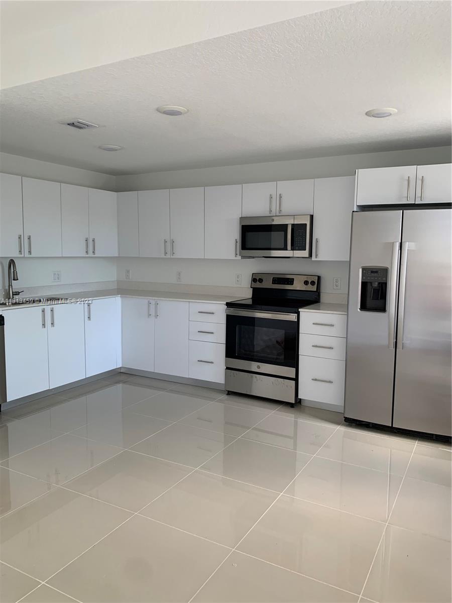 25680 Southwest 143rd Avenue Homestead, FL 33032 - Photo 2 of 20 a kitchen with granite countertop a cabinets and steel stainless steel appliances