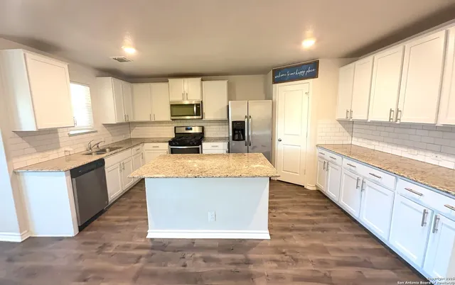 a large kitchen with stainless steel appliances granite countertop a stove a sink dishwasher and a refrigerator