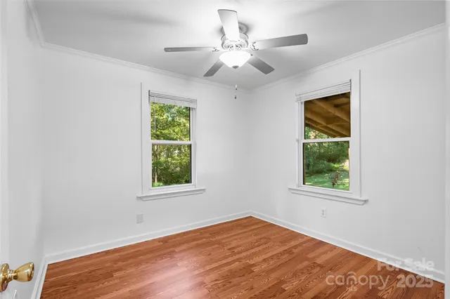 an empty room with a window and wooden floor