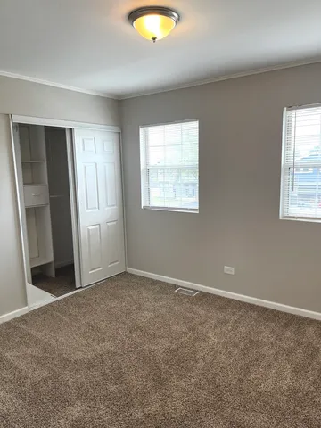 an empty room with windows and closet