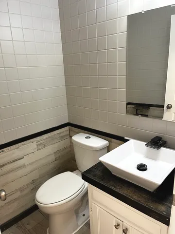 a bathroom with a sink a toilet and a mirror