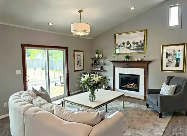 a living room with furniture a chandelier and a fireplace