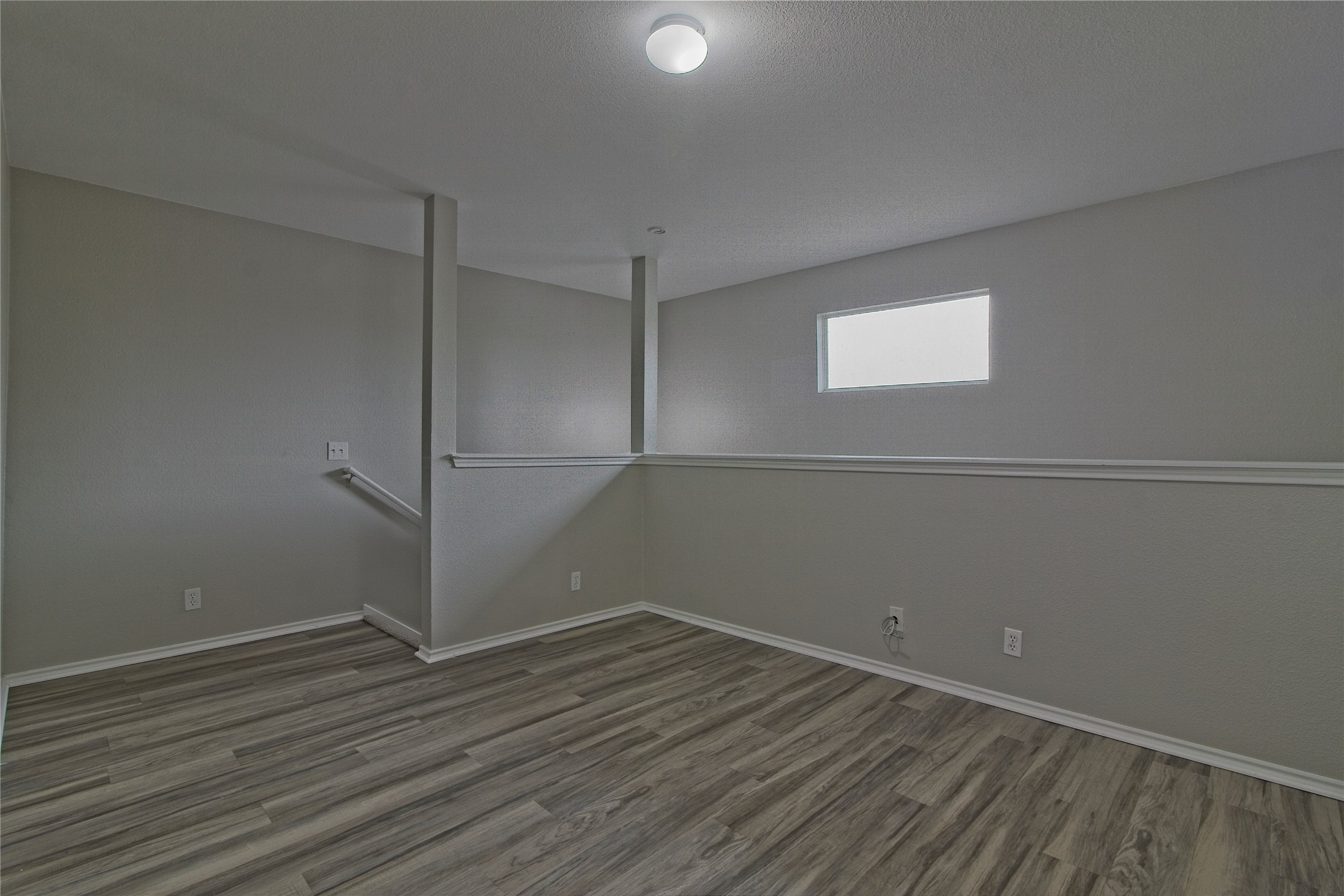 232 Brickyard Lane Jarrell, TX 76537 - Photo 21 of 31 A versatile open-plan area offers flexible space for various needs, featuring wood flooring and modern lighting.