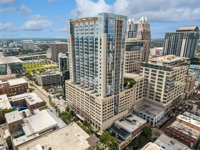 a kitchen with stainless steel appliances granite countertop a refrigerator a stove top oven and a dining table with wooden floor