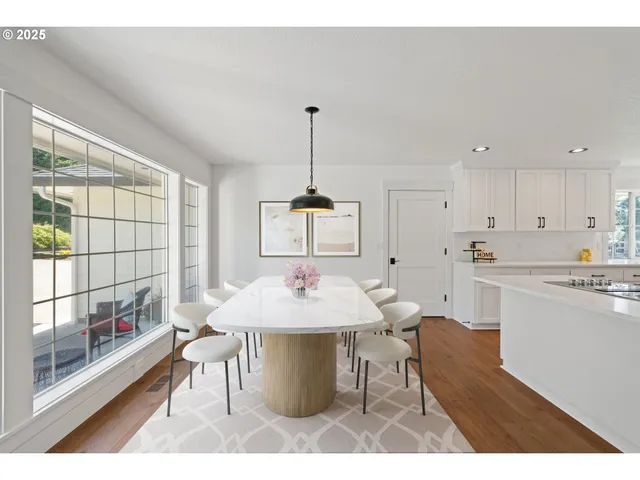 a dining room with a table chairs and a kitchen view