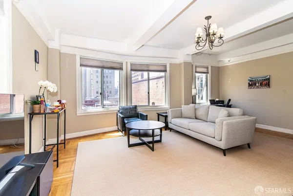 a living room with furniture and a chandelier