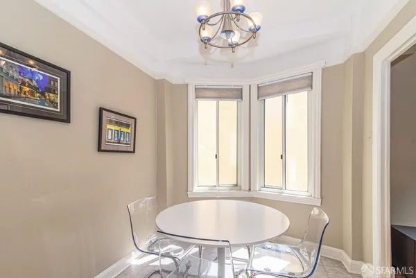 a view of a dining room with furniture a chandelier and a window