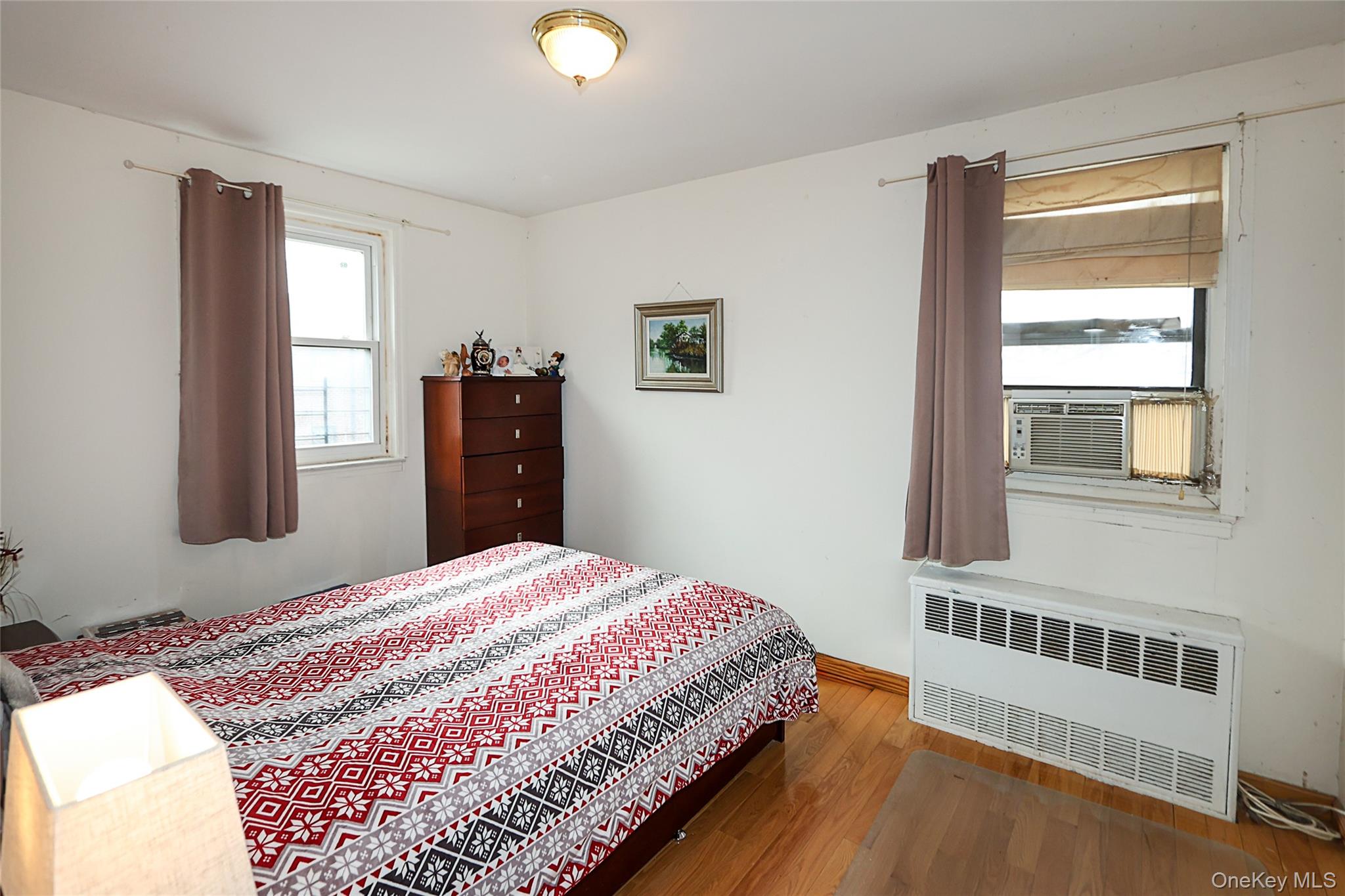 196-23 73rd Avenue, Unit 2 Queens, NY 11366 - Photo 13 of 19 a bedroom with a bed and wooden floor