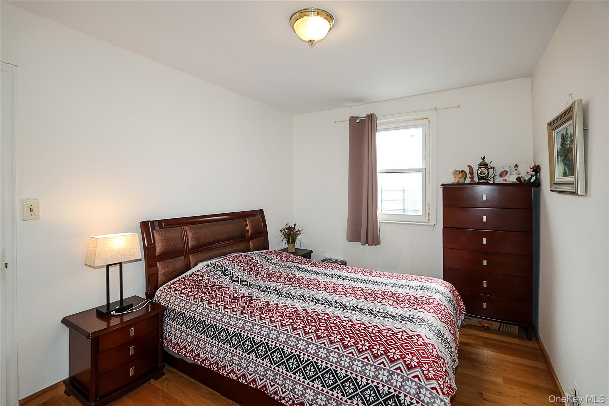 196-23 73rd Avenue, Unit 2 Queens, NY 11366 - Photo 14 of 19 a bedroom with a bed and a lamp