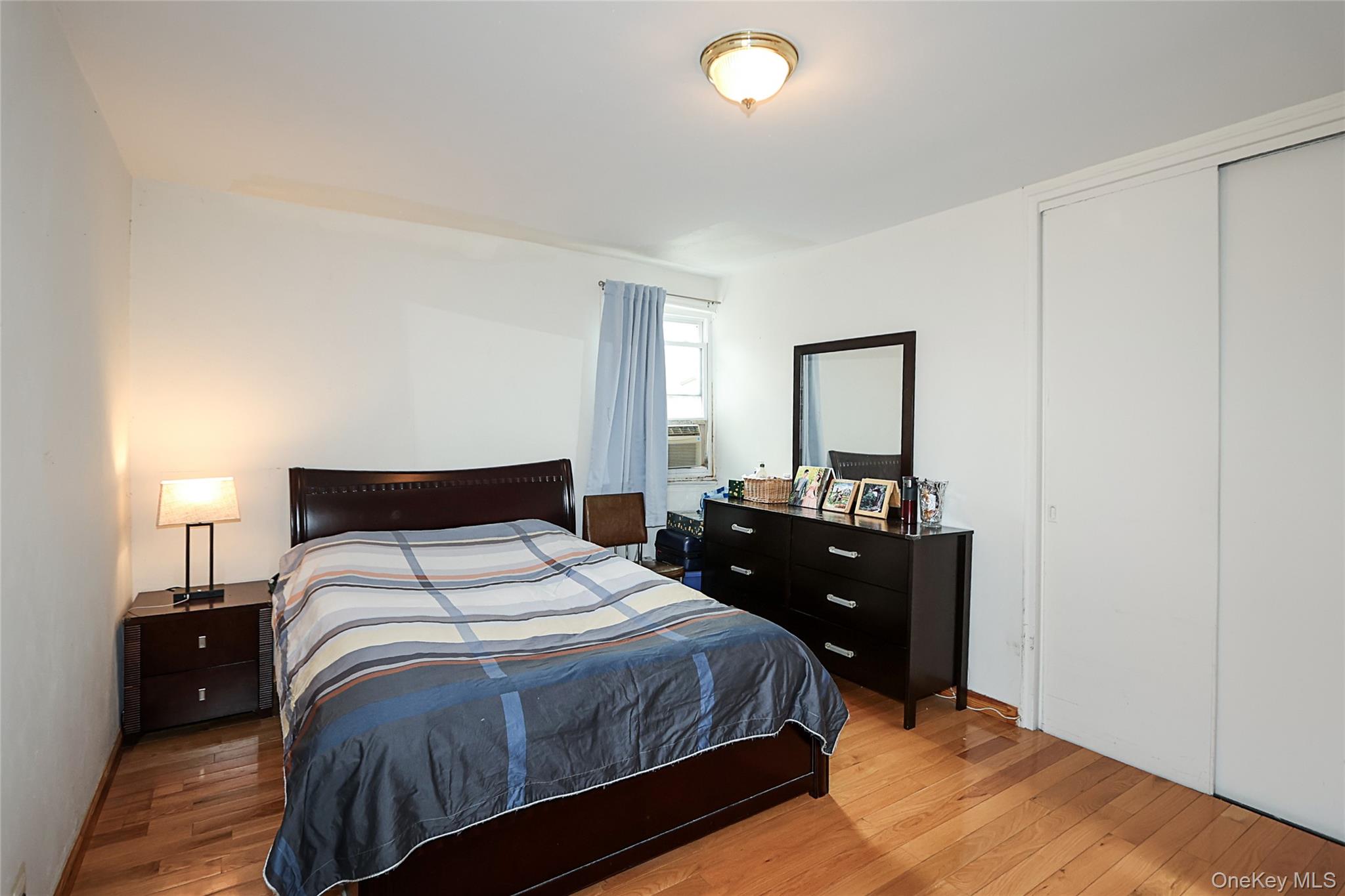 196-23 73rd Avenue, Unit 2 Queens, NY 11366 - Photo 16 of 19 a bedroom with a bed and a lamp