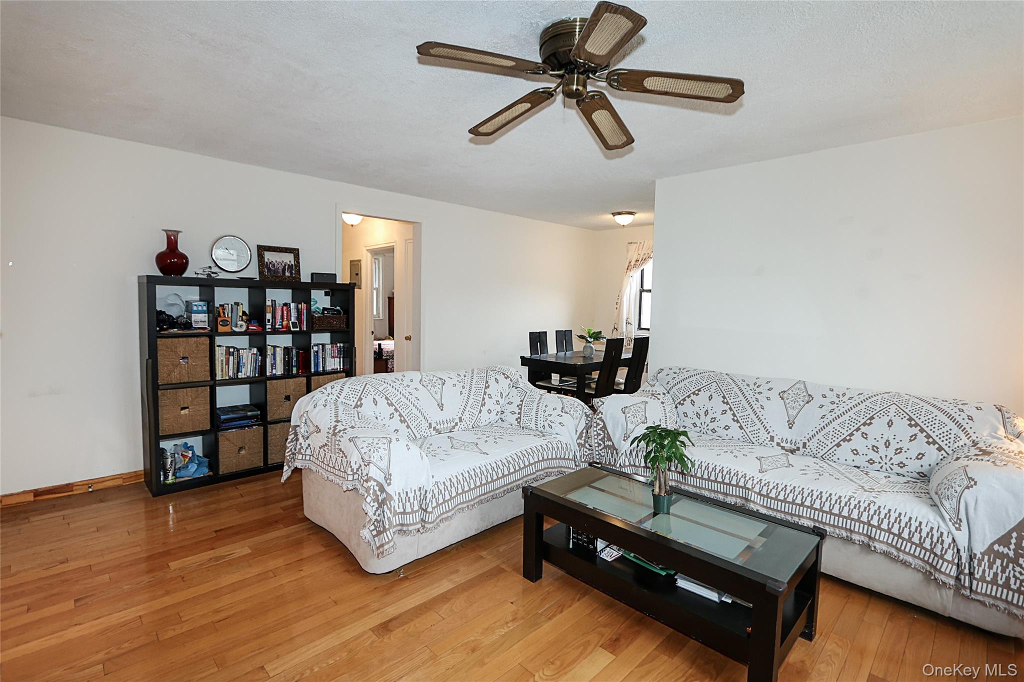 196-23 73rd Avenue, Unit 2 Queens, NY 11366 - Photo 5 of 19 a living room with furniture and a book shelf