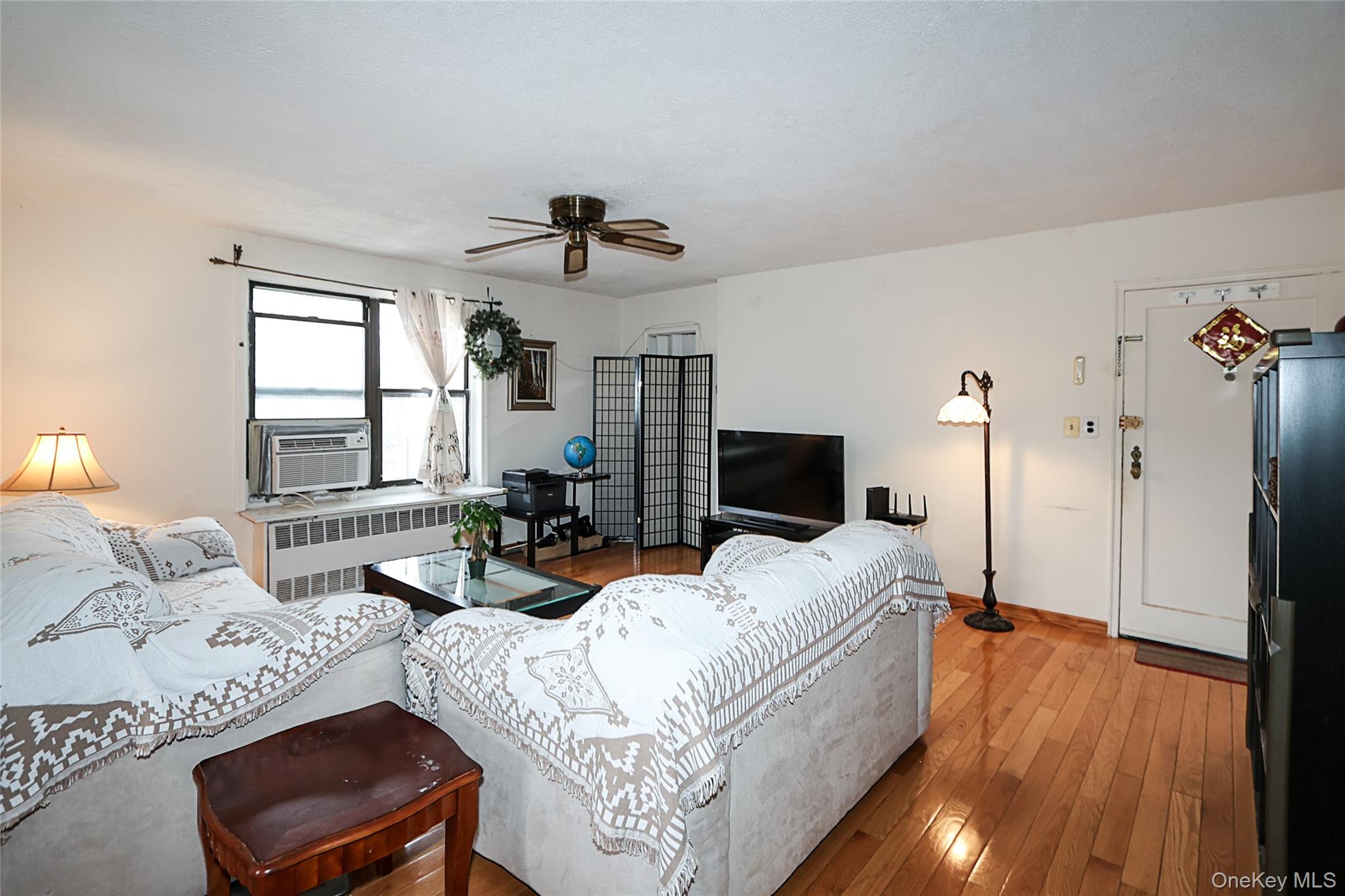 196-23 73rd Avenue, Unit 2 Queens, NY 11366 - Photo 7 of 19 a living room with furniture and a flat screen tv