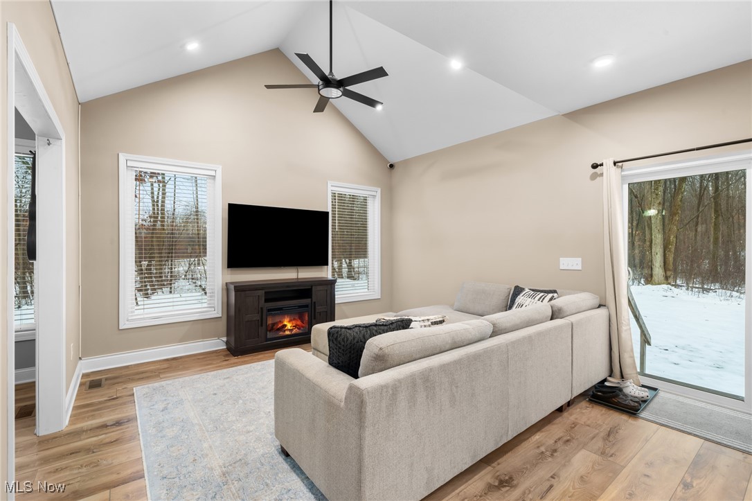 39600 Aurora Road Solon, OH 44139 - Photo 10 of 49 Living room featuring a glass covered fireplace, high vaulted ceiling, recessed lighting and a ceiling fan