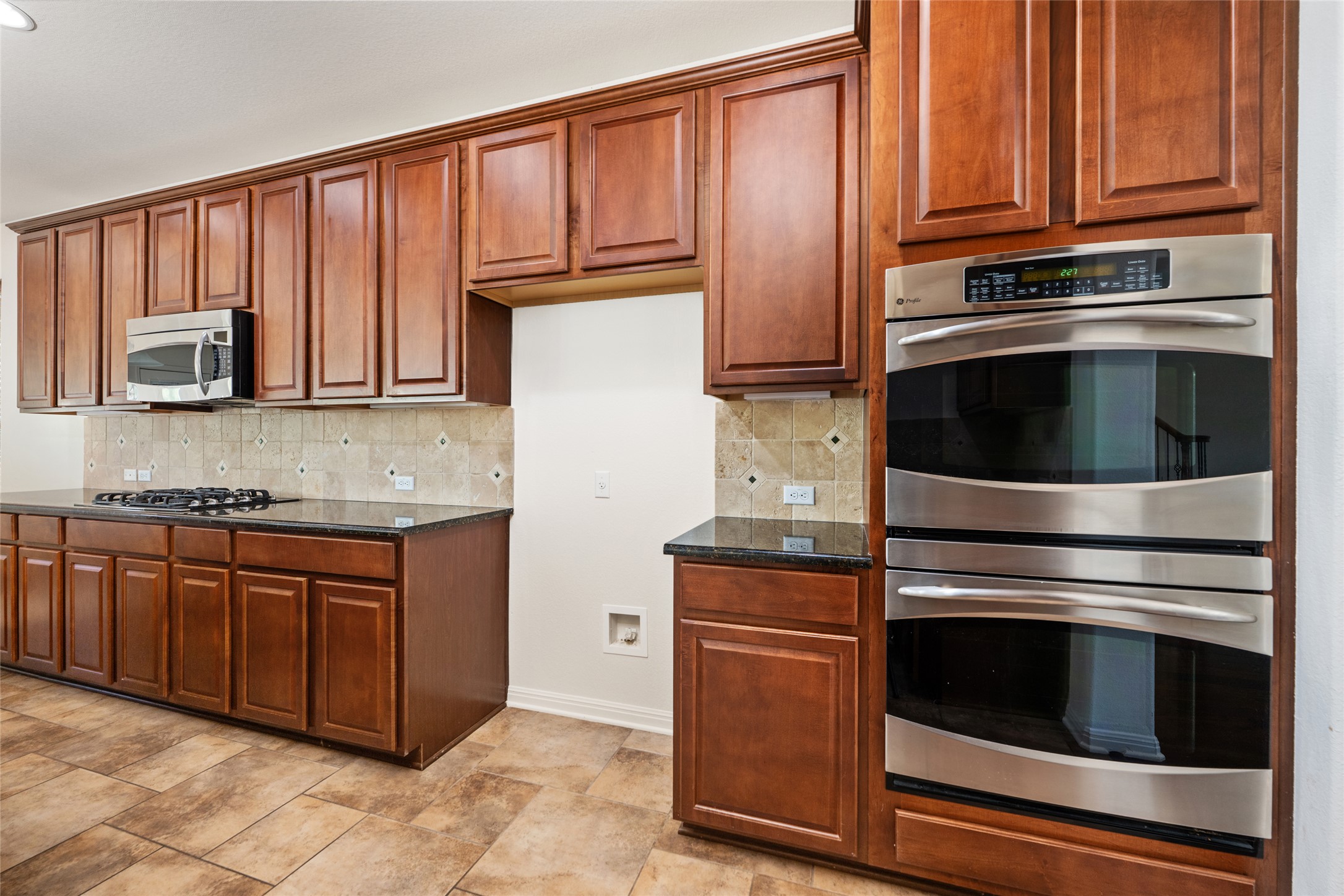 15205 Spillman Ranch Loop Austin, TX 78738 - Photo 19 of 40 A well-appointed kitchen showcasing rich cabinetry, sleek granite countertops, and modern stainless steel appliances.