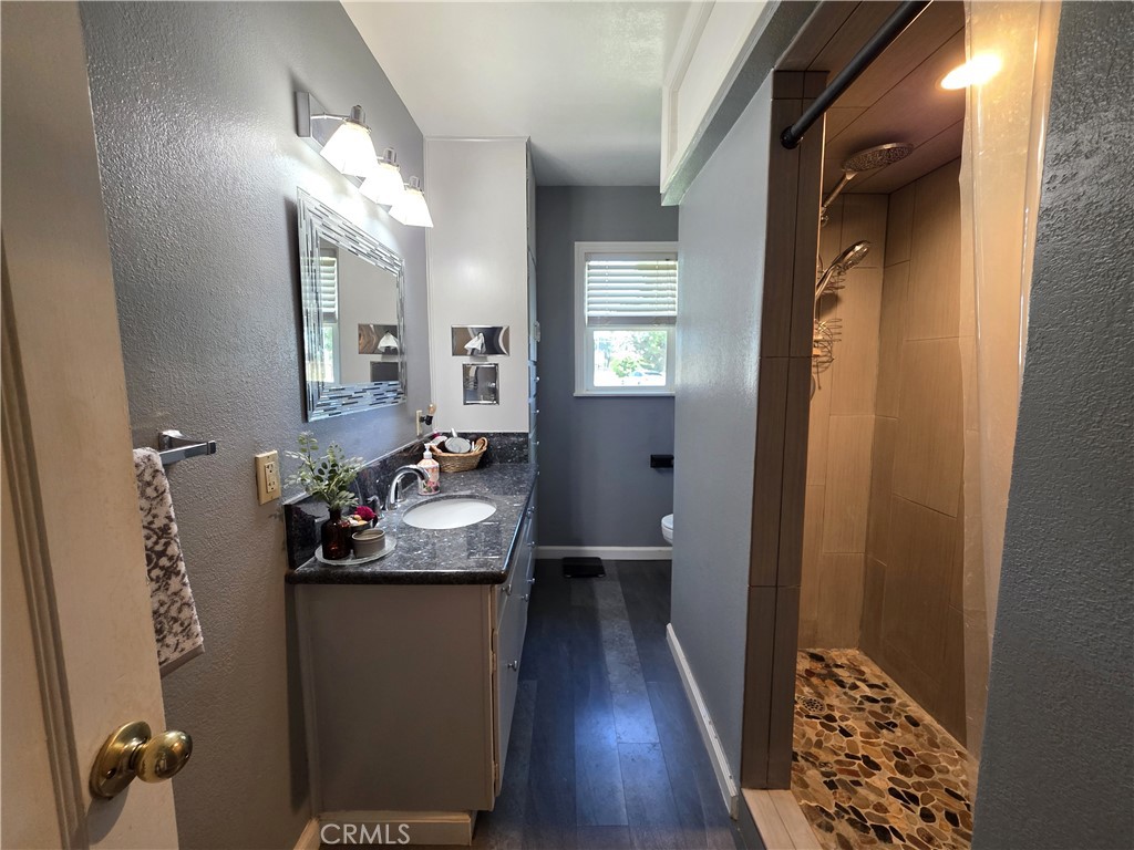23773 River Road Corning, CA 96021 - Photo 21 of 64 a bathroom with a sink and mirror with toilet