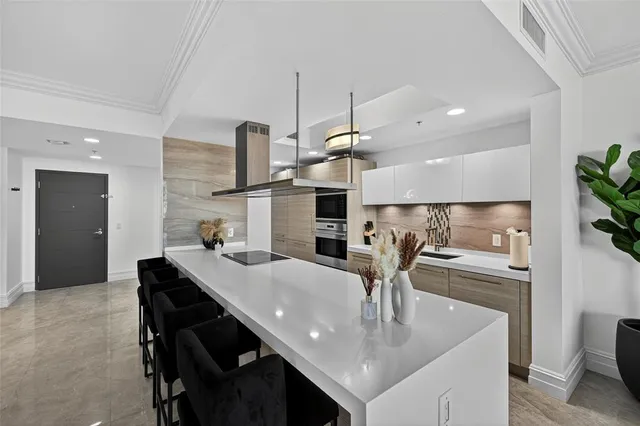 a kitchen with stainless steel appliances granite countertop a sink a stove and chairs