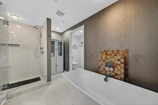 a spacious bedroom with a bed and a chandelier