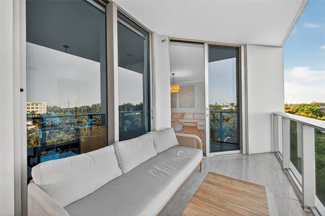 a spacious bedroom with a bed and a large window with balcony view