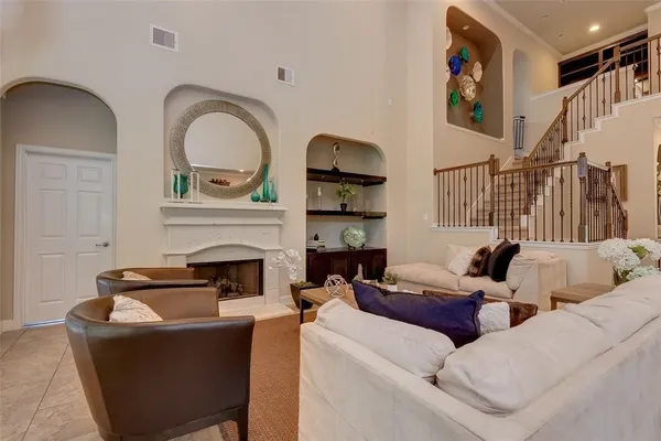a living room with furniture a fireplace and gym equipment