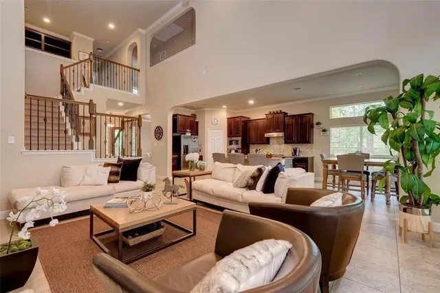 a living room with furniture kitchen view and a potted plant