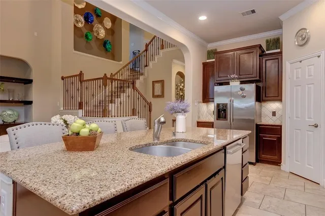 a kitchen with a sink refrigerator and cabinets
