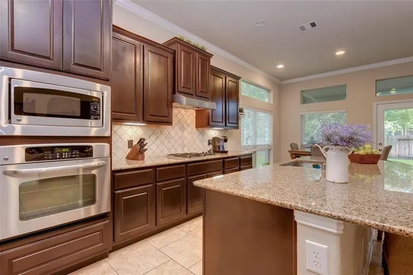a kitchen with granite countertop stainless steel appliances and wooden cabinets