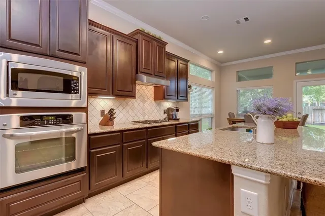 a kitchen with granite countertop stainless steel appliances and wooden cabinets