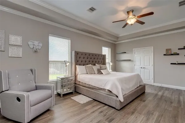 a bedroom with a large bed couch and windows