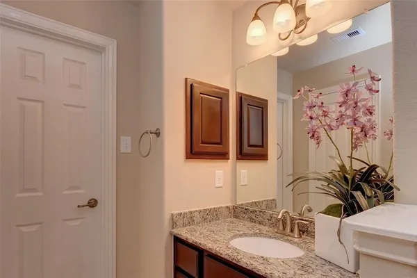 a bathroom with a granite countertop sink a large mirror and a shower