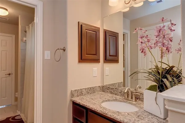 a bathroom with a granite countertop sink and a mirror
