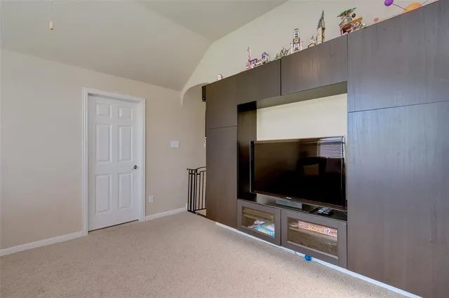 a living room with flat screen tv and gym equipment