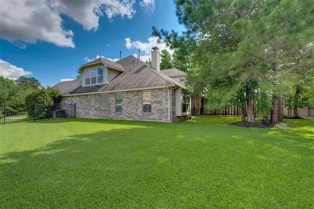 a view of a house with a big yard potted plants and large tree
